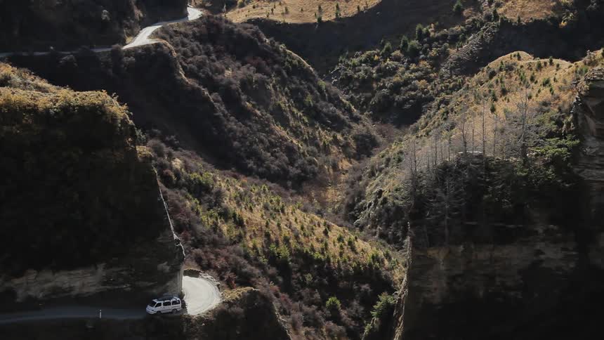 A van driving upwards on a sharply winding mountain road