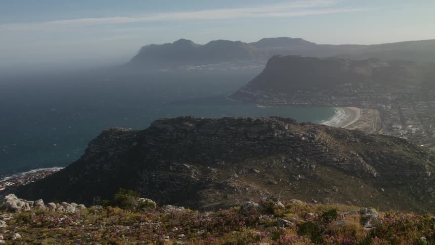 A hill overlooks an ocean cove on a sunny day