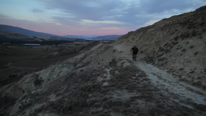 Person riding their mountain bike down a path on a mountain