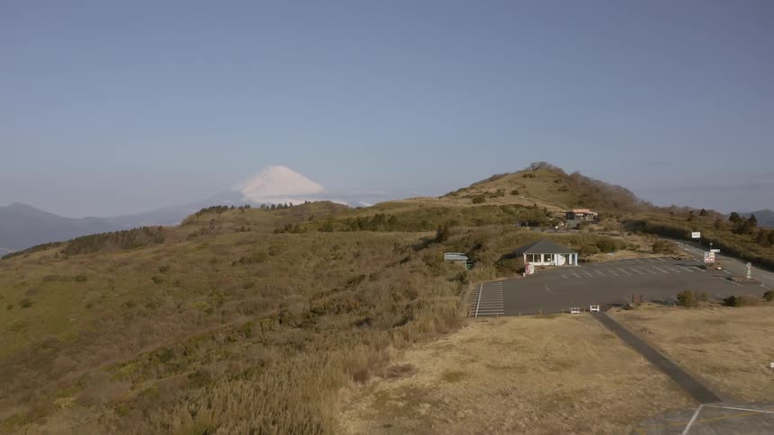 A parking lot is sitting empty on a hillside in a natural landscape on a sunny day