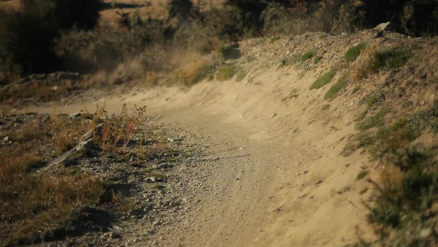 Man riding his bike around a turn on a dirty trail
