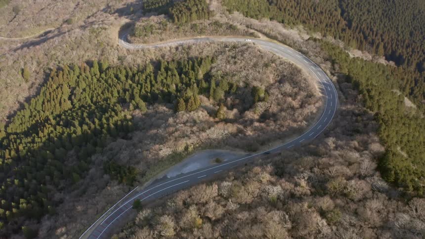 Vehicles drive on a country road on a sunny day