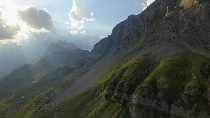 Sun shines out from behind clouds over mountains