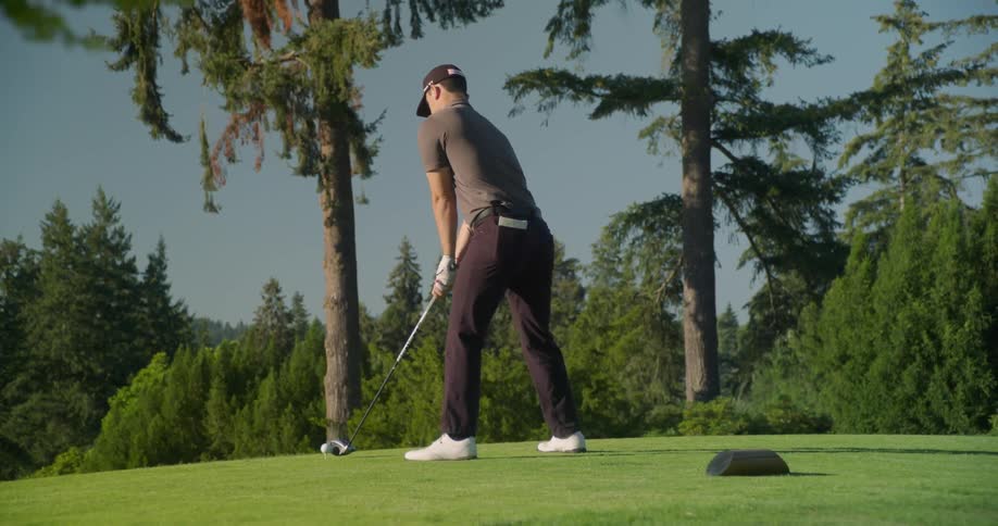 Man plays golf on a green on a sunny day