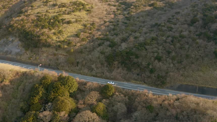 Car travels down a highway on a sunny day