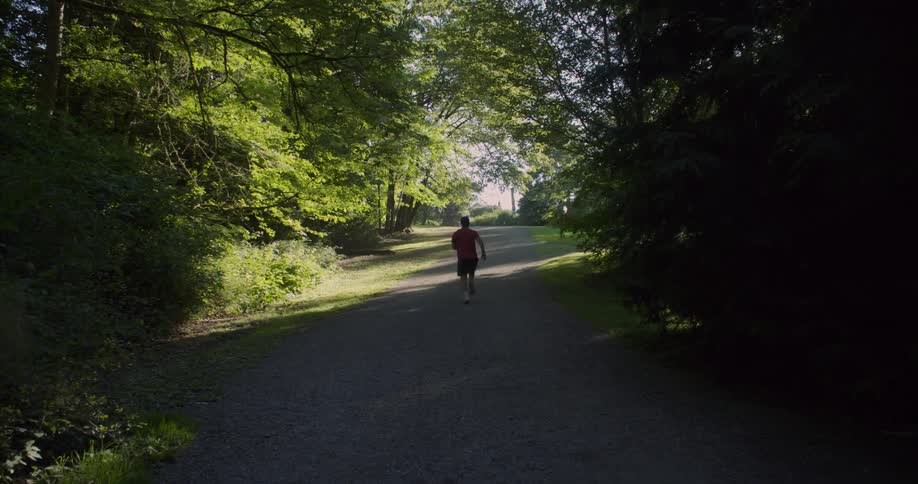The man races down the trail covered in shadow