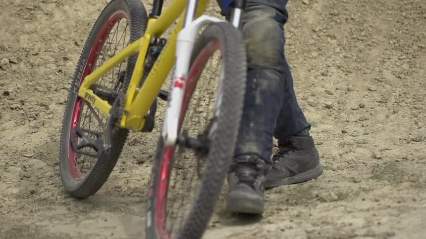 Man walks over to a bike and picks up it