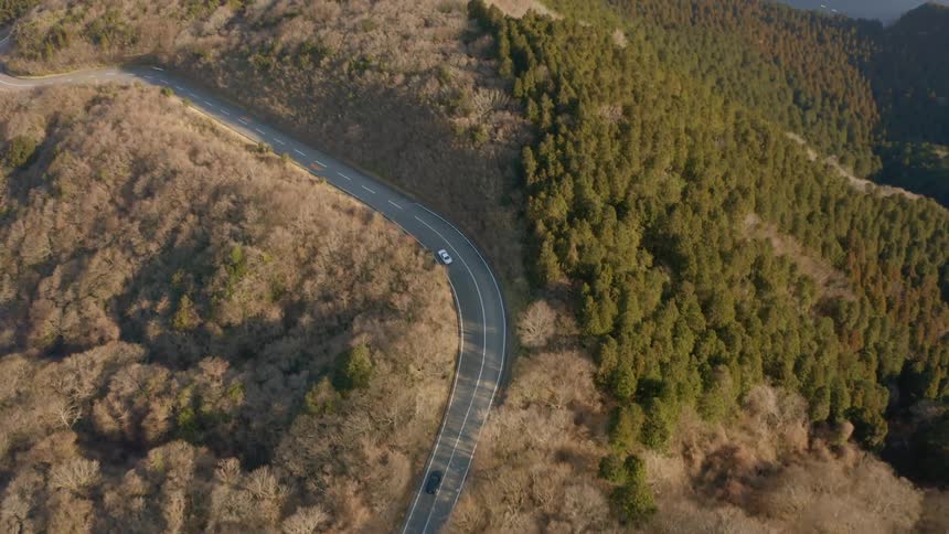 Cars drive on a mountain road