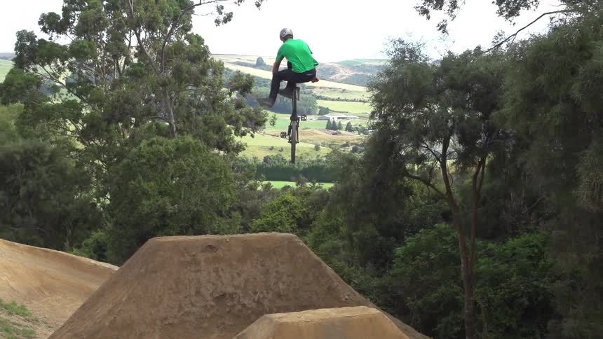 Man riding his bike up ramps and doing jumps in the dirt
