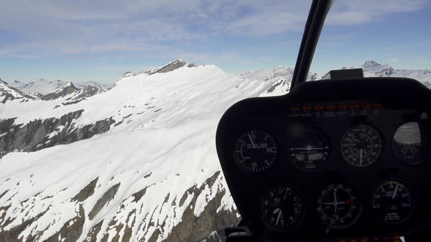 View from inside a flying aircraft over a snow covered mountain
