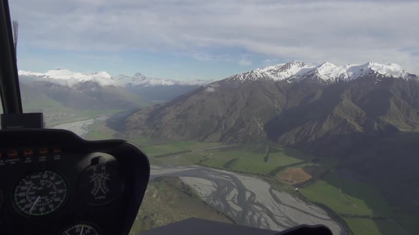 A helicopter flies over a mountain range