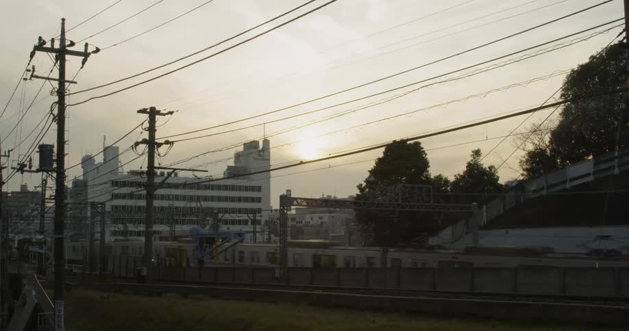 Sun shining over Tokyo and a passing train