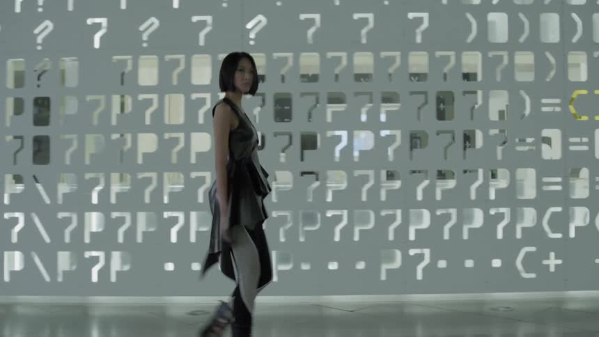 The woman walks past the building