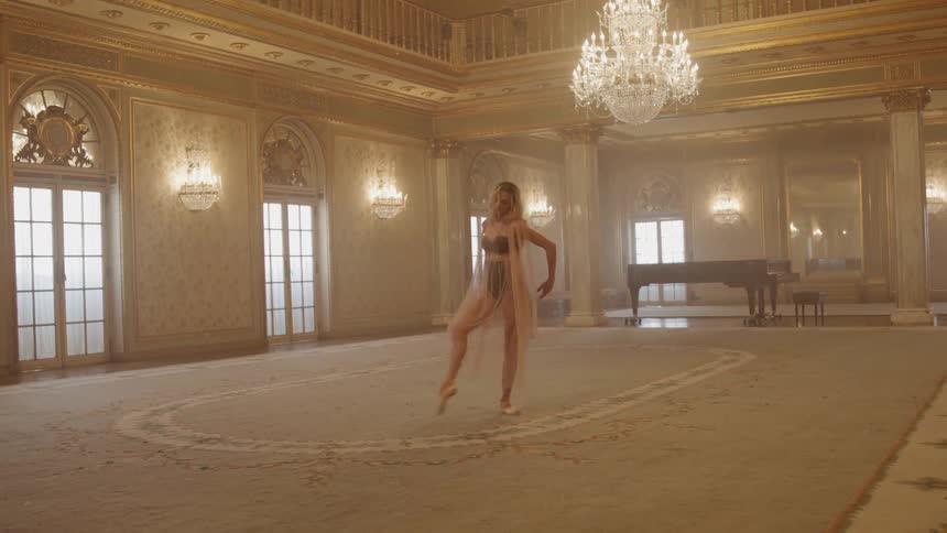 Woman practices dance moves in a large ballroom