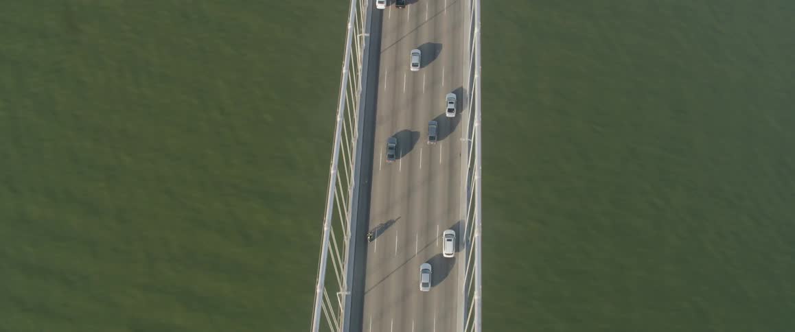 The vehicles cross the bridge together below