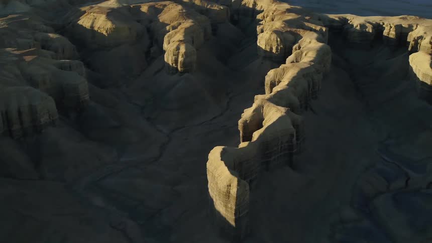 Shadows fall over hilly desert landscape on a sunny day