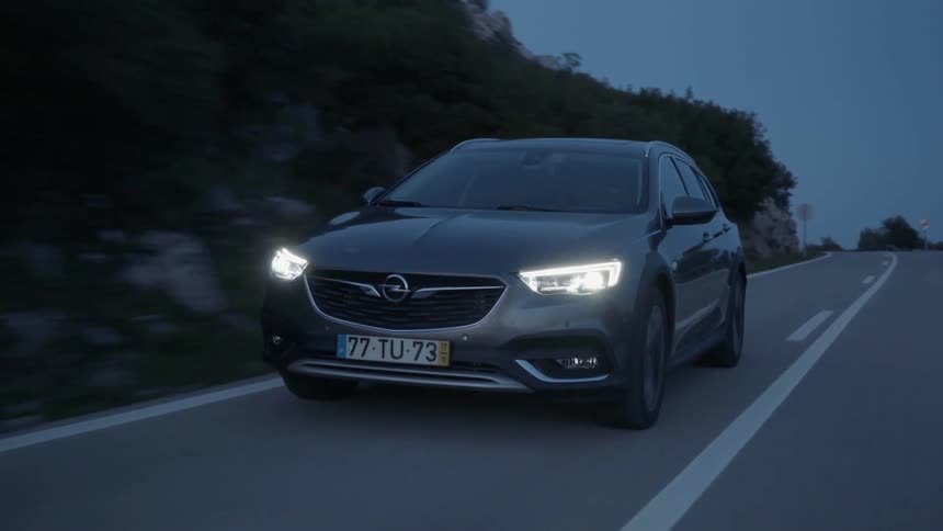 Car drives down a country road in the evening