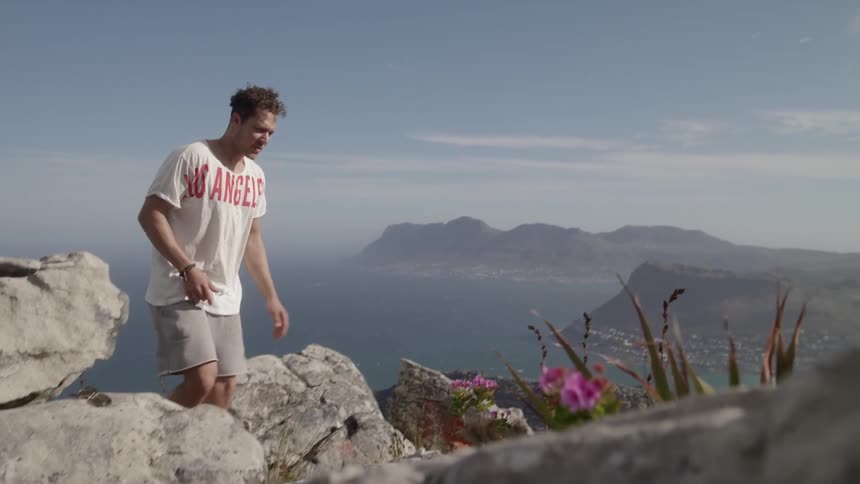 Man climbs up on rocks on a sunny day