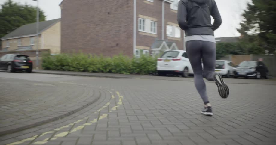 Woman jogs down a city street