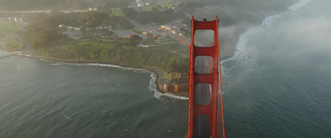 The clouds touch the top of the bridge