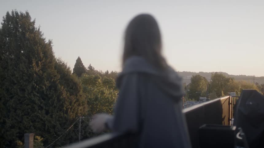 Woman leaning on a balcony railing looking out