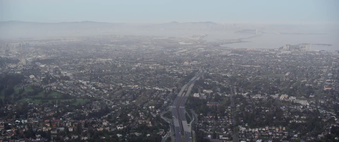 Haze is lingering in the air over a city on a coastline during the day