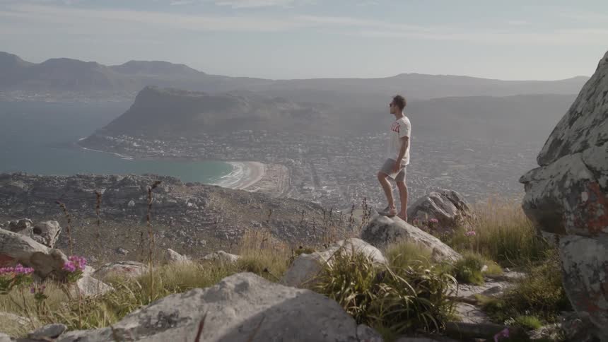 A man stands on a rock on the hill