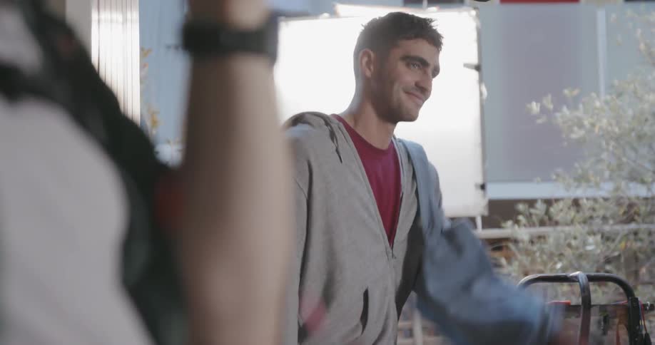 A man looks at a bottle and pretends to toss it to someone