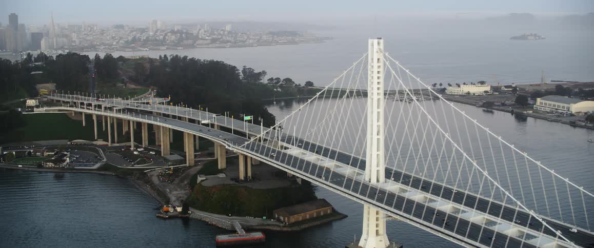 White bridge over a large body of water leading into a city
