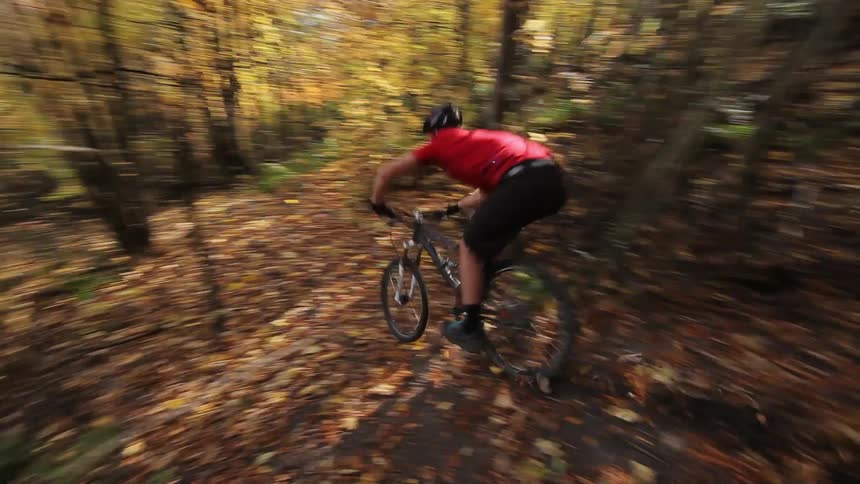 A man is riding his bike down a muddy hill