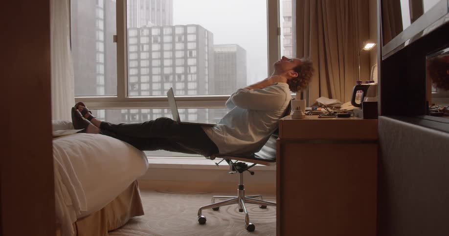 A man uses a laptop in a hotel room