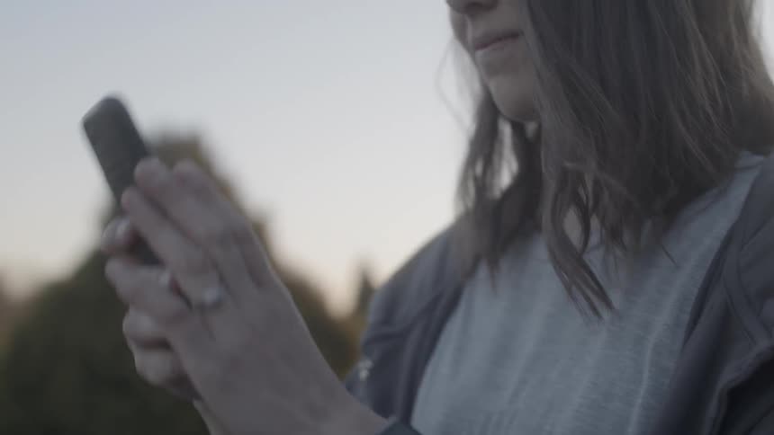 Woman removes her cell phone from her pocket and takes a photo with it