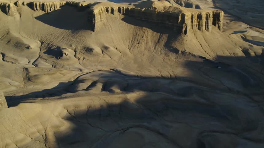 Shadows fall over hilly desert landscape on a sunny day