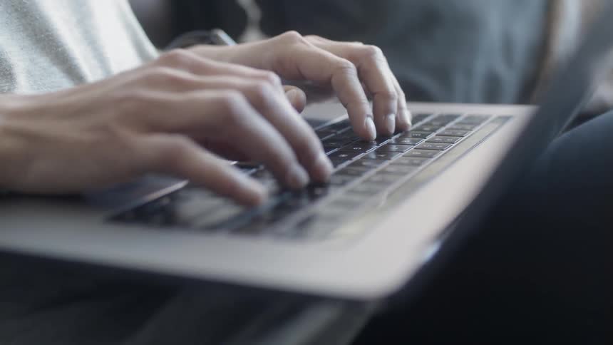 A person is typing on their laptop