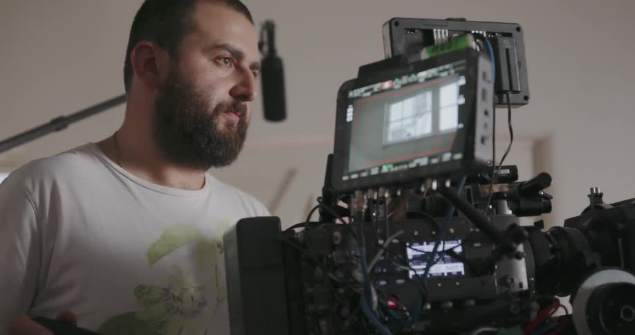 Man stands next to video equipment nodding his head