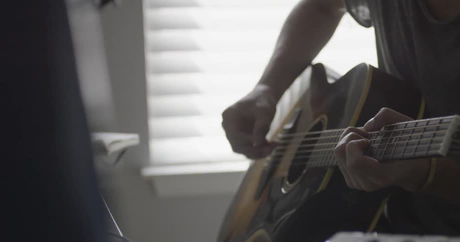 A person is playing a guitar in the studio