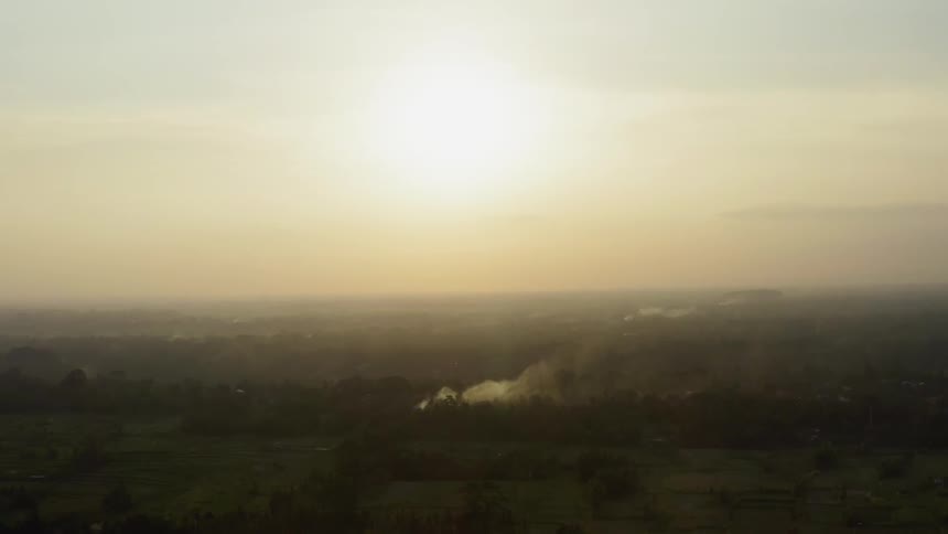 The sun sets over a rural landscape