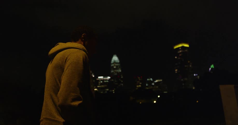 A man is walking at night in the city