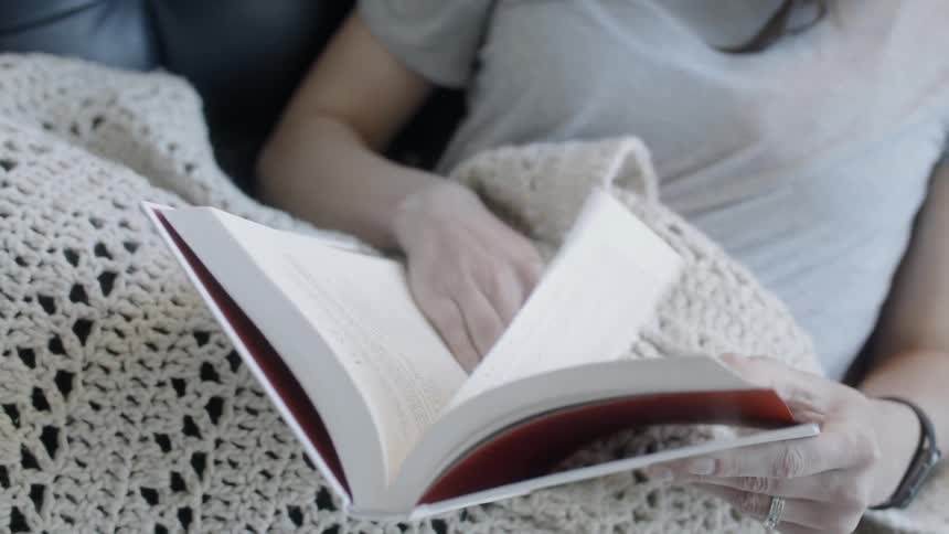 Woman reads a book in bed