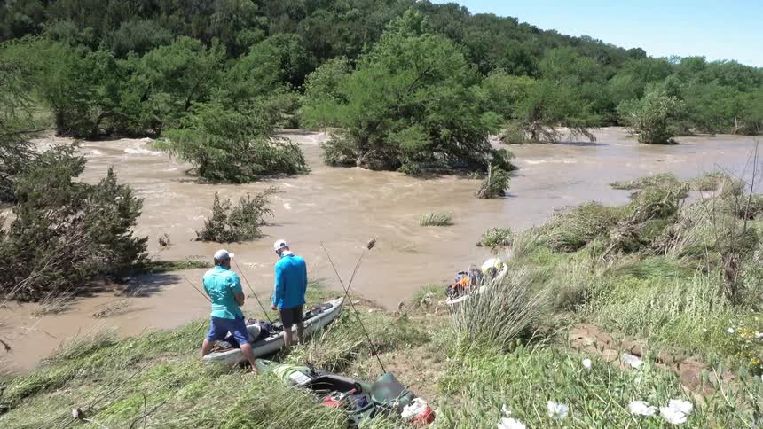 Two people in a small canoe near rushing water