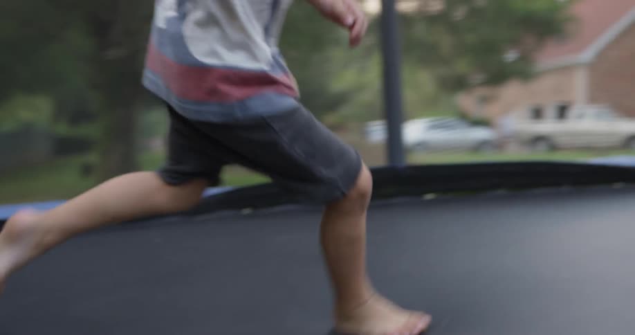 A young child plays on a trampoline