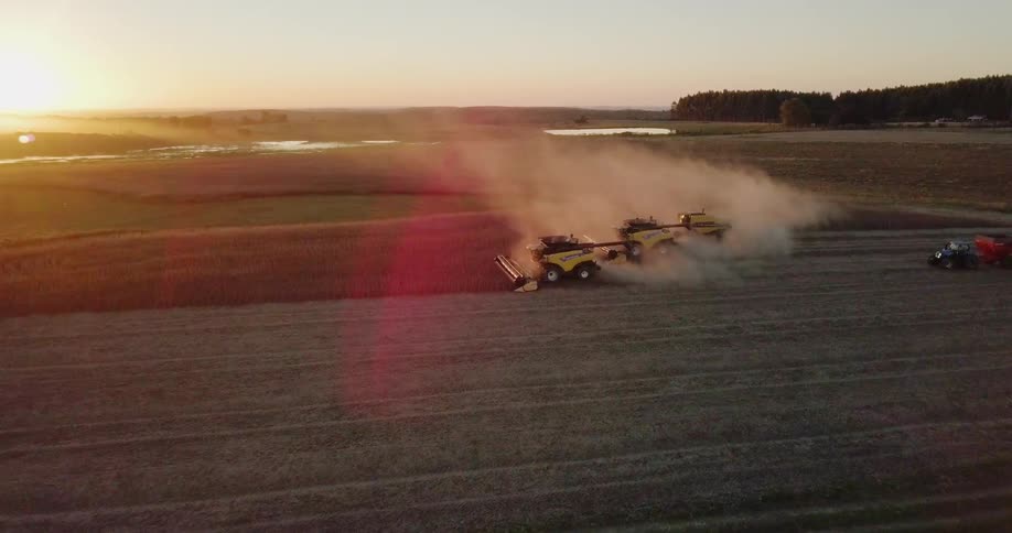 The farm vehicles are working the field together