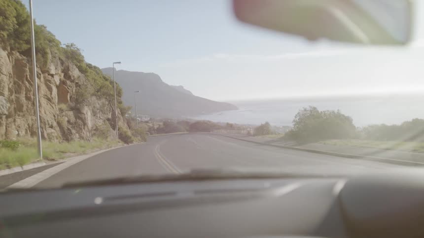 Car drives down a sunny country road