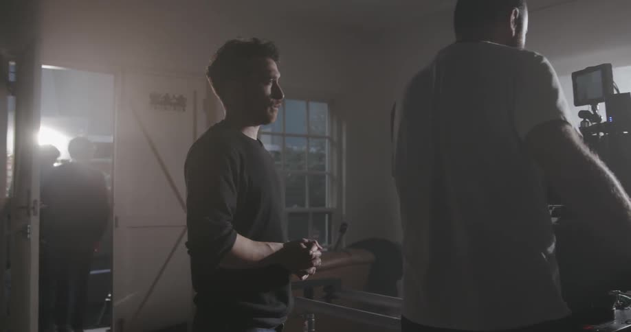 Several men recording with large cameras in a house on a sunny day