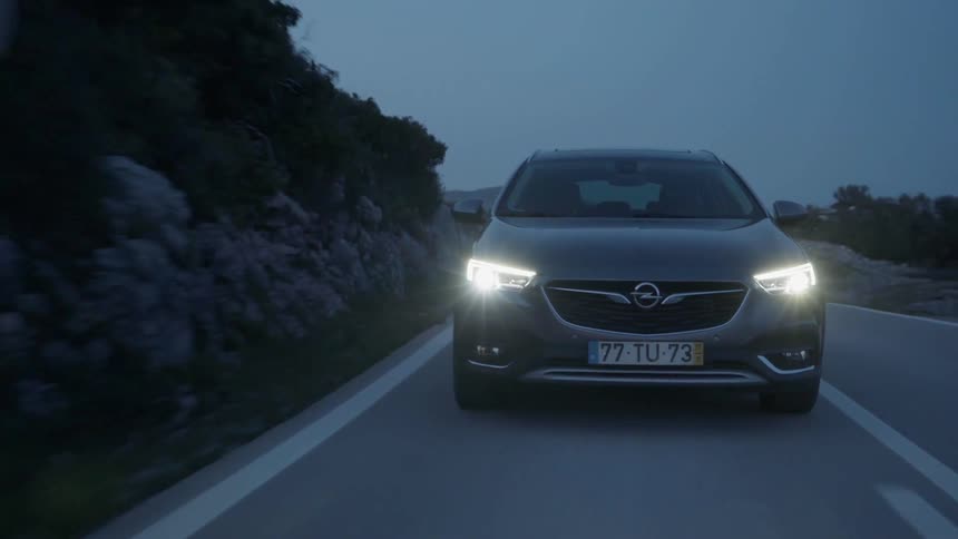 Car drives down a country road in the evening