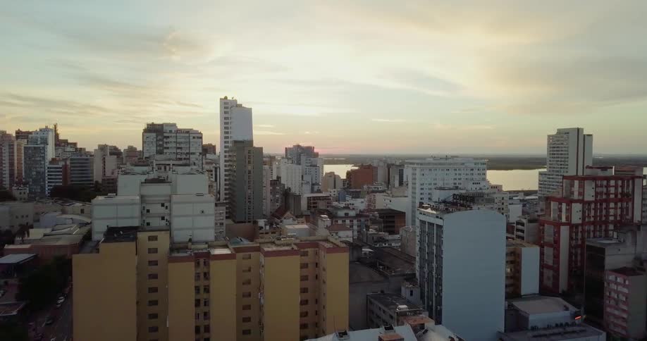 Sun shines over a large city next to a body of water