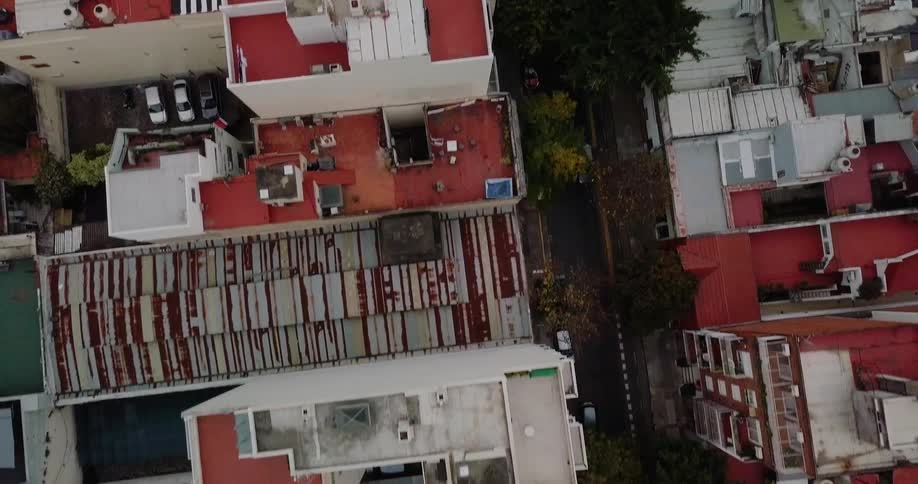 Cars parked on a city street in between two large building