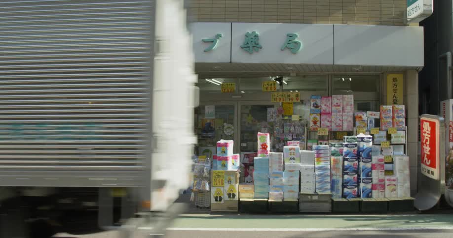 Truck drives past a small shop in Tokyo