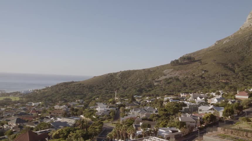 City sits at the base of the mountain under a blue sky