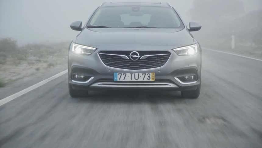 Car drives down a country road on a cloudy day